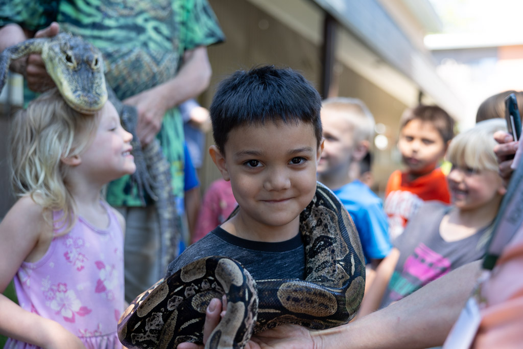 Snake around shoulders of young boy